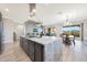 Open concept kitchen with island seating flowing into the dining and living areas at 13236 W Montansoro Ln, Peoria, AZ 85383