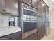 Built-in stainless steel microwave and oven beside coffee maker and refrigerator at 13236 W Montansoro Ln, Peoria, AZ 85383