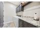 Functional laundry room with modern washer and dryer, granite countertop, and ample cabinet space at 13236 W Montansoro Ln, Peoria, AZ 85383
