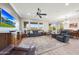 Comfortable living room with large windows, ceiling fan, and leather seating at 13236 W Montansoro Ln, Peoria, AZ 85383