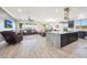 Open floor plan with wood floors, island kitchen, and living room area at 13236 W Montansoro Ln, Peoria, AZ 85383