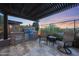Outdoor kitchen with a built-in grill, travertine patio and desert views at 13236 W Montansoro Ln, Peoria, AZ 85383
