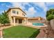 Home's backyard featuring a pool, artificial turf, and patio area, great for outdoor living at 13443 W Crocus Dr, Surprise, AZ 85379