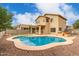 Wide shot of backyard with in-ground pool, patio, barbecue, and manicured landscaping at 13443 W Crocus Dr, Surprise, AZ 85379
