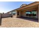 The backyard features a covered patio with desert landscaping and a beautiful brick privacy wall at 14045 W Desert Flower Dr, Goodyear, AZ 85395