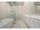Bathroom with a soaking tub, separate glass shower, dual sink vanity with white cabinets, and tile flooring at 14045 W Desert Flower Dr, Goodyear, AZ 85395