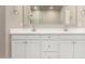 Bathroom features double sink vanity, white cabinets, and expansive mirror at 14045 W Desert Flower Dr, Goodyear, AZ 85395