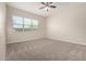 Bedroom with neutral carpeting, ceiling fan, and ample natural light from the window at 14045 W Desert Flower Dr, Goodyear, AZ 85395