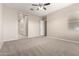 Primary bedroom with neutral carpet features ceiling fan, and ample natural light at 14045 W Desert Flower Dr, Goodyear, AZ 85395