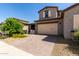 Inviting two-story home featuring a brick driveway, two-car garage, and well-maintained landscaping at 14045 W Desert Flower Dr, Goodyear, AZ 85395