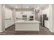 Bright kitchen featuring white cabinets, stainless steel appliances, an island with marble countertop, and pendant lighting at 14045 W Desert Flower Dr, Goodyear, AZ 85395