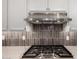 Close-up of kitchen showing stainless steel gas range and stylish backsplash at 14045 W Desert Flower Dr, Goodyear, AZ 85395