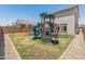 Backyard view with a play structure surrounded by grass, perfect for children to play and enjoy the outdoors at 14435 W El Cortez Pl, Surprise, AZ 85387