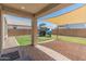 Spacious backyard with a patio, green lawn, and a play structure for children at 14435 W El Cortez Pl, Surprise, AZ 85387