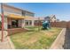 A large backyard with a patio, play structure, and plenty of green space for outdoor activities at 14435 W El Cortez Pl, Surprise, AZ 85387