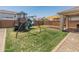 A Gathering-friendly backyard with a play structure, swings, and a shaded patio area for outdoor relaxation at 14435 W El Cortez Pl, Surprise, AZ 85387