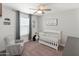 Cozy Bedroom featuring a crib, rocking chair, and natural light at 14435 W El Cortez Pl, Surprise, AZ 85387