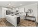 Bright kitchen featuring white cabinetry, stainless steel appliances, and a spacious island with quartz countertop at 14435 W El Cortez Pl, Surprise, AZ 85387