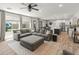 Spacious living room with an oversized sectional, view of the kitchen, dining area, and access to the backyard at 14435 W El Cortez Pl, Surprise, AZ 85387