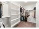 Spacious walk-in closet featuring custom shelving, hanging rods, and plush carpeting at 14435 W El Cortez Pl, Surprise, AZ 85387