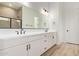 Bathroom features double sinks, a huge mirror and a glass door shower and wood look tile floors at 15833 W Bronco Trl, Surprise, AZ 85387