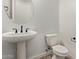 Powder room featuring a pedestal sink with modern black faucet and matching hardware at 15833 W Bronco Trl, Surprise, AZ 85387