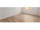Bright bedroom featuring wood-look tile flooring, white walls, and a window providing natural light at 15833 W Bronco Trl, Surprise, AZ 85387
