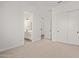 Spacious bedroom featuring carpet, white walls, closet, and an ensuite bathroom at 15833 W Bronco Trl, Surprise, AZ 85387