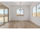 Bright dining room features wood-look tile floors and a modern light fixture at 15833 W Bronco Trl, Surprise, AZ 85387
