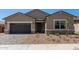 Charming single-Gathering home with desert landscaping, stone accents, a two car garage and a stone paver driveway at 15833 W Bronco Trl, Surprise, AZ 85387