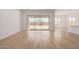 Open living room with wood-look tile and sliding glass doors to backyard at 15833 W Bronco Trl, Surprise, AZ 85387