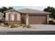 Charming single-story home featuring stone accents, a two-car garage, and professionally landscaped front yard at 16009 W Bronco Trl, Surprise, AZ 85387