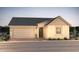 Single story home with stucco siding, brick driveway, two car garage and desert landscaping at 16448 W Whispering Wind Dr, Surprise, AZ 85387