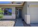 Charming home entrance features a well-maintained yard, arched window, and a welcoming blue front door at 18174 E Via Jardin --, Gold Canyon, AZ 85118