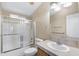 Bathroom showcasing a shower-tub combination with glass doors and a neutral color scheme at 201 S Greenfield Rd # 173, Mesa, AZ 85206
