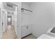Long hallway with laminate flooring and a laundry room with storage cabinets and countertops at 27510 N 30Th Ln, Phoenix, AZ 85083