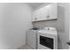 Clean laundry room equipped with modern washer and dryer, plus ample storage in white cabinets at 27510 N 30Th Ln, Phoenix, AZ 85083