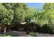 Private backyard showcasing mature trees, lush green foliage, and raised garden beds at 4018 E Adobe Dr, Phoenix, AZ 85050