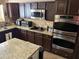 Kitchen with stainless steel appliances, double ovens, stone backsplash and dark cabinetry at 4018 E Adobe Dr, Phoenix, AZ 85050