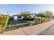 Quaint home featuring a brick and grass driveway, manicured lawn and mature trees at 4021 E Glenrosa Ave, Phoenix, AZ 85018