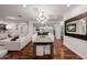 Open-concept living space showcasing a dining area, modern chandelier, and hardwood floors at 4021 E Glenrosa Ave, Phoenix, AZ 85018