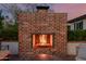 Brick outdoor fireplace with fire burning, and comfortable seating area at 4021 E Glenrosa Ave, Phoenix, AZ 85018
