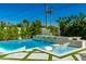 Inviting pool with luxurious lounge seating, waterfall feature, and meticulously designed travertine tile and turf accents at 4021 E Glenrosa Ave, Phoenix, AZ 85018
