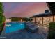Backyard pool featuring a sundeck with fire bowls, artificial turf, and access to covered seating at 4021 E Glenrosa Ave, Phoenix, AZ 85018