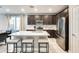 Modern kitchen featuring dark cabinetry, stainless steel appliances, and a large center island with seating at 4046 S 58Th Ln, Phoenix, AZ 85043