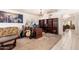 Spacious living room featuring large bookshelf, guitars, and neutral carpet at 4441 E Desert Wind Dr, Phoenix, AZ 85044