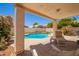 Covered patio overlooking a sparkling swimming pool and lush landscaping at 4441 E Desert Wind Dr, Phoenix, AZ 85044