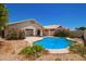 Backyard pool surrounded by desert landscaping and covered patio at 4441 E Desert Wind Dr, Phoenix, AZ 85044
