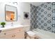 Stylish bathroom with a patterned accent wall, a single sink vanity, and a bathtub with shower at 4712 E Lone Cactus Dr, Phoenix, AZ 85050