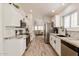 Modern kitchen with stainless steel appliances, white cabinets and granite countertops, open to the living area at 4712 E Lone Cactus Dr, Phoenix, AZ 85050